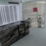 Рецепция от естествен гранит на фона на ламперия от акрилен High Gloss с подсветка от LED диодно осветление.